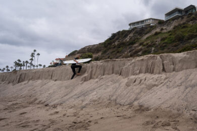 Le spiagge della California si stanno progressivamente restringendo . Un surfista risale un ripido pendio sabbioso a North Beach, a San Clemente (California) (Foto AP/Jae C. Hong)