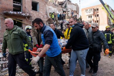 Residenti e soccorritori trasportano i corpi delle vittime di un attacco missilistico russo contro un edificio residenziale a Pryluky in Ucraina (Foto AP/Evgeniy Maloletka)