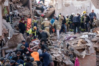 Residenti e soccorritori trasportano i corpi delle vittime di un attacco missilistico russo contro un edificio residenziale a Pryluky in Ucraina (Foto AP/Evgeniy Maloletka)