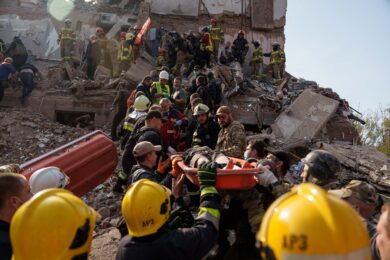 Residenti e soccorritori trasportano i corpi delle vittime di un attacco missilistico russo contro un edificio residenziale a Pryluky in Ucraina (Foto AP/Evgeniy Maloletka)