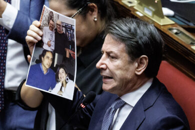 Giuseppe Conte mostra le foto di Delmastro e Colosimo insieme a Caroccia e Ciavardini durante le dichiarazioni di voto finale sulla legge elettorale alla Camera dei deputati (Foto Roberto Monaldo / LaPresse)