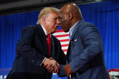 Il presidente Donald Trump saluta Mike Tyson durante un comizio elettorale all'Oncenter a Syracuse, nello stato di New York. (Foto AP/Julia Demaree Nikhinson)