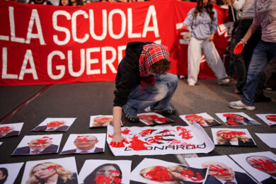 A terra immagini con i volti dei ministri Valditara e Crosetto, del presidente Meloni e di Elly Schlein e il logo di Leonardo, imbrattate di rosso al corteo studentesco a Torino (Foto Marco Alpozzi/Lapresse)