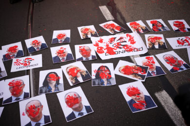 A terra immagini con i volti dei ministri Valditara e Crosetto, del presidente Meloni e di Elly Schlein e il logo di Leonardo, imbrattate di rosso al corteo studentesco a Torino (Foto Marco Alpozzi/Lapresse)